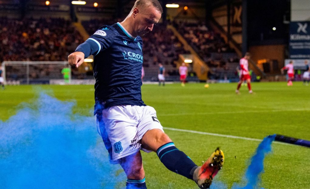 DUNDEE, SCOTLAND - SEPTEMBER 22: Dundee's Leigh Griffiths kicks a blue smoke bomb thrown on by St Johnstone fans during a Premier Sports Cup quarter-final match between Dundee and St Johnstone at the Kilmac Stadium at Dens Park, on September 22, 2021, in Dundee, Scotland. (Photo by Ross Parker / SNS Group)